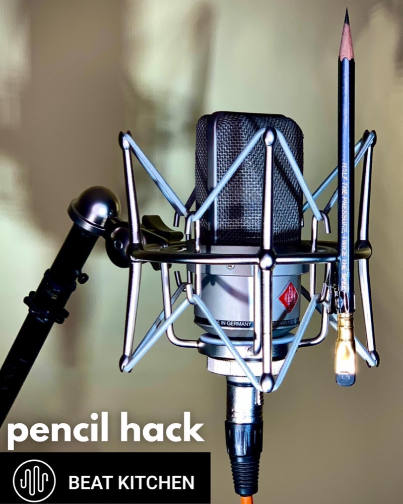 Neumann microphone with pencil wedged in shock mount — the pencil hack for plosives